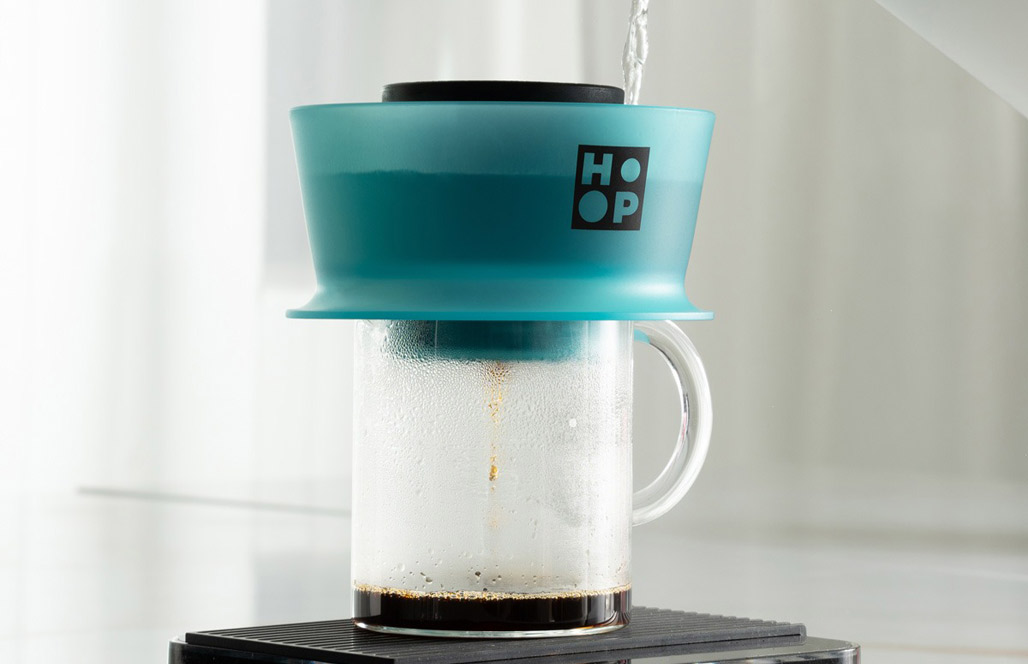Pouring water into the Hoop, brewing into a glass mug